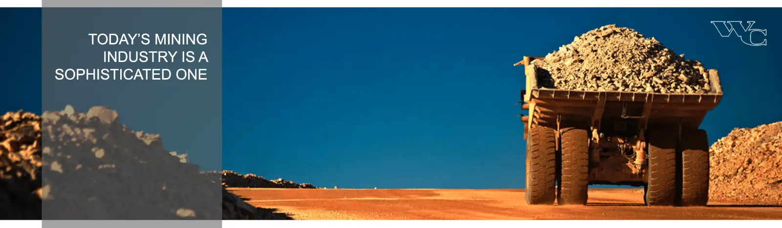 Large mining truck loaded with gravel driving across a dirt road under a clear blue sky, with text overlay reading 'Today's Mining Industry is a Sophisticated One.' Highlights the modern advancements and scale of the mining industry.